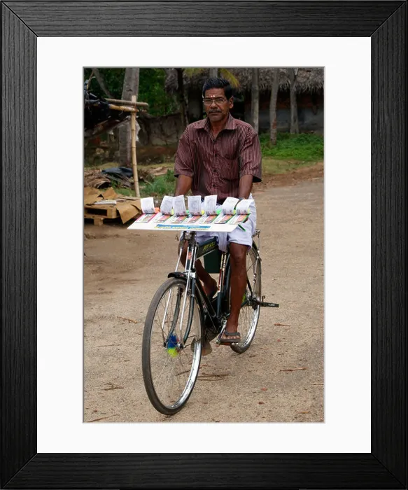 Framed Print : Lottery ticket seller riding bicycle scene from Kerala Framed Print : Lottery ticket seller riding bicycle scene from Kerala