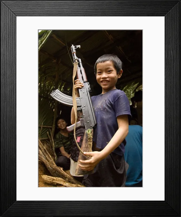 Framed Print : Hmong boy hold AK 47 while hiding in the jungles of Laos Framed Print : Hmong boy hold AK 47 while hiding in the jungles of Laos