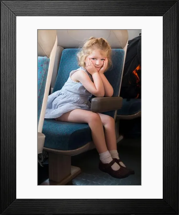 Framed Print : Child / kid / girl passenger sitting on a seat on a French train in France Framed Print : Child / kid / girl passenger sitting on a seat on a French train in France