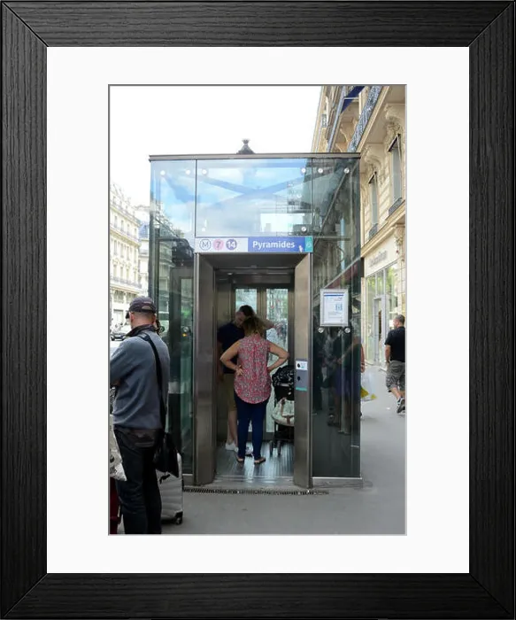 Framed Print : A glass elevator leads from the street down into the Paris Metro Framed Print : A glass elevator leads from the street down into the Paris Metro