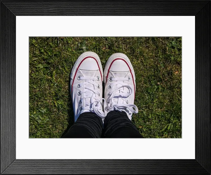 Framed Print : Girl's white Converse trainers standing on short grass looking from above Framed Print : Girl's white Converse trainers standing on short grass looking from above