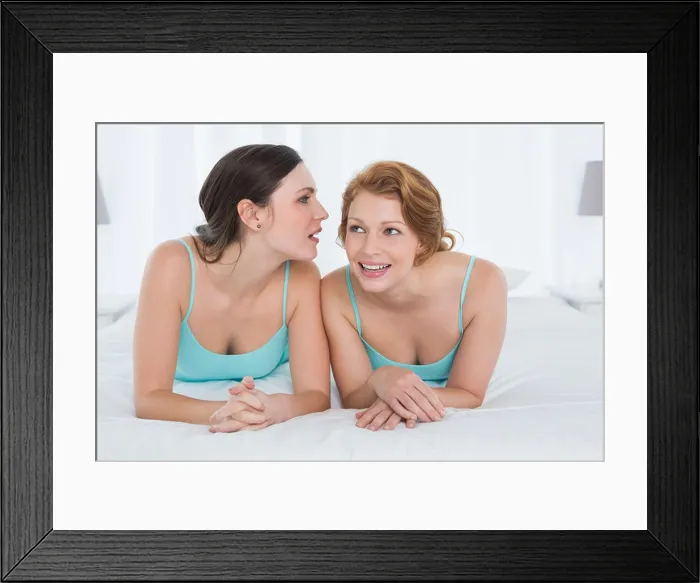 Framed Print : Female friends in tank tops gossiping in bed Framed Print : Female friends in tank tops gossiping in bed