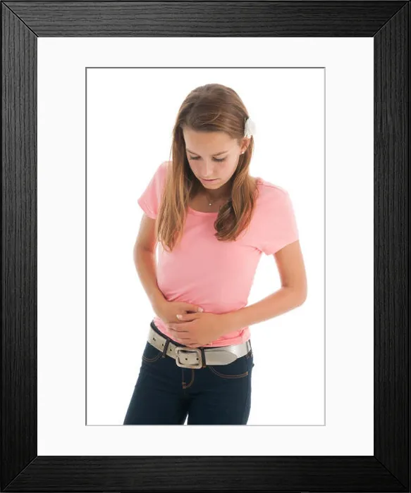 Framed Print : Teen girl with belly ache isolated over white background Framed Print : Teen girl with belly ache isolated over white background