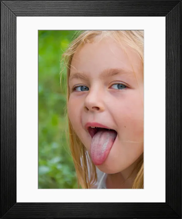 Framed Print : Portrait of cute girl with put out tongue Framed Print : Portrait of cute girl with put out tongue