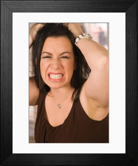 Framed Print : Angry young woman grits her teeth and pulls her hair out in frustration, USA Framed Print : Angry young woman grits her teeth and pulls her hair out in frustration, USA