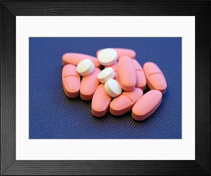 Framed Print : Large pink oval-shaped tablets and small white round tablets. Pills against a blue background. Vitamin D3 in pills Framed Print : Large pink oval-shaped tablets and small white round tablets. Pills against a blue background. Vitamin D3 in pills