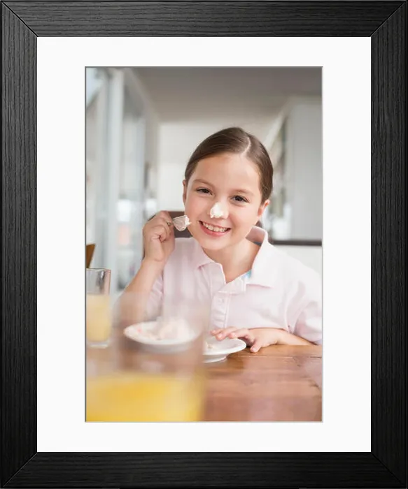 Framed Print : Playful girl smearing cake on her nose Framed Print : Playful girl smearing cake on her nose