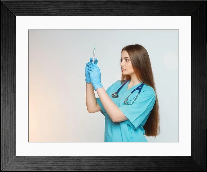 Framed Print : a female doctor holds a syringe in her hand Framed Print : a female doctor holds a syringe in her hand