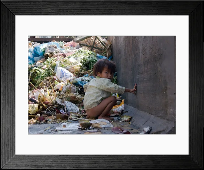 Framed Print : A young girl is defecating in a dumpster filled with garbage on a trash strewn street in Phnom Penh, Cambodia Framed Print : A young girl is defecating in a dumpster filled with garbage on a trash strewn street in Phnom Penh, Cambodia