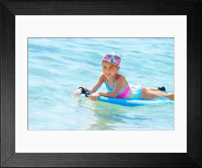 Framed Print : Happy little girl with bodyboard in blue transparent sea, enjoying water sport, having fun in summer camp Framed Print : Happy little girl with bodyboard in blue transparent sea, enjoying water sport, having fun in summer camp