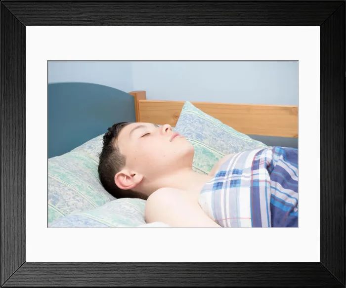 Framed Print : Young caucasian teenage boy asleep in his bed