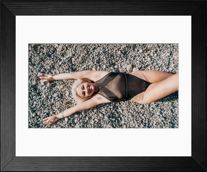 Framed Print : Woman in a Black Swimsuit on Pebble Beach Framed Print : Woman in a Black Swimsuit on Pebble Beach