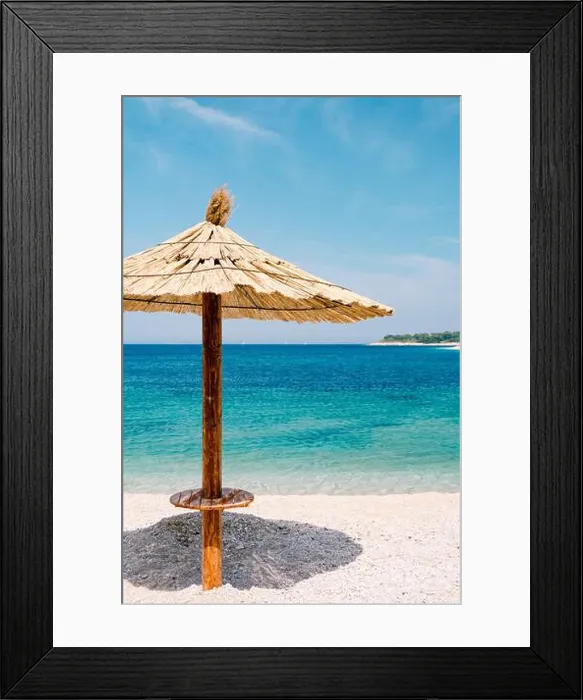 Framed Print : A beach thatched umbrella against the blue sky and azure water on a sandy beach in Croatia, in the city of Primosten Framed Print : A beach thatched umbrella against the blue sky and azure water on a sandy beach in Croatia, in the city of Primosten
