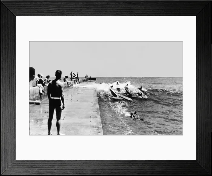 Framed Print : California surfers catching a wave along the Newport Harbor jetty in Corona del Mar in the early 1930s Framed Print : California surfers catching a wave along the Newport Harbor jetty in Corona del Mar in the early 1930s