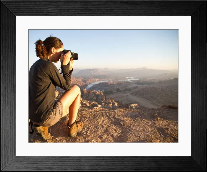 Framed Print : India, Karnataka, Young female tourist photographing on top of hill in Hampi Framed Print : India, Karnataka, Young female tourist photographing on top of hill in Hampi