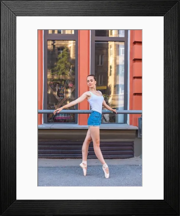 Framed Print : Young ballerina in a white shirt and jeans shorts dancing in pointe shoes on a street Framed Print : Young ballerina in a white shirt and jeans shorts dancing in pointe shoes on a street