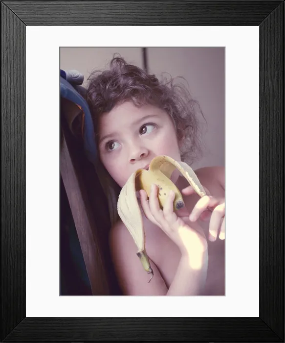 Framed Print : Little girl eating banana Framed Print : Little girl eating banana