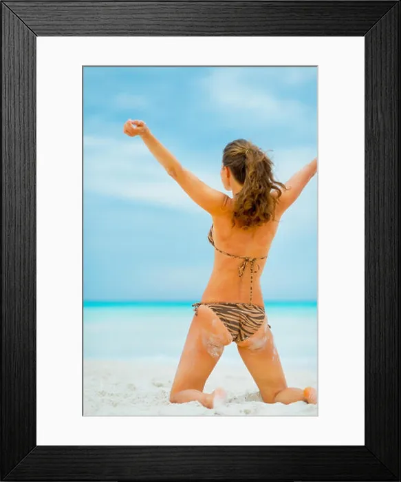 Framed Print : Young woman rejoicing on beach. rear view Framed Print : Young woman rejoicing on beach. rear view
