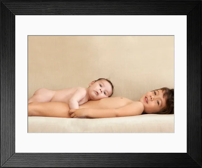 Framed Print : A young boy and his baby brother lying on the couch Framed Print : A young boy and his baby brother lying on the couch