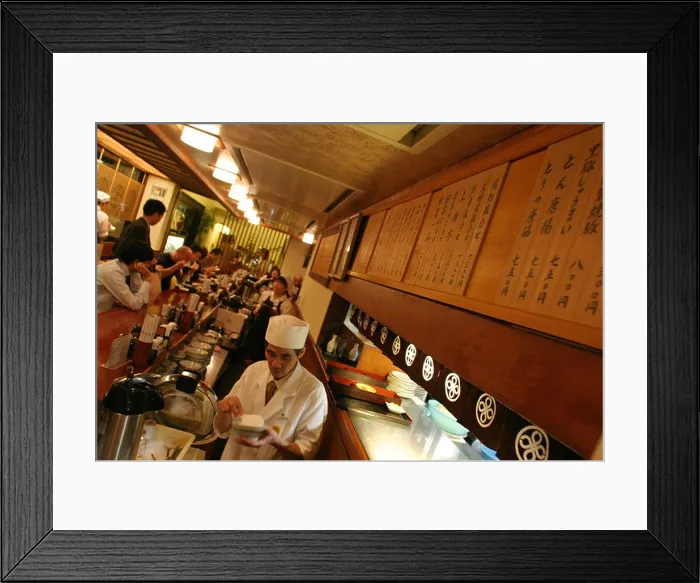 Framed Print : Maisen restaurant in Aoyama district, Tokyo, Japan. a waiter in white clothes prepares food