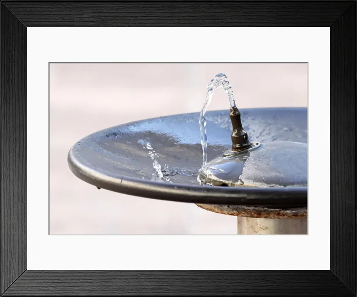 Framed Print : Water flowing from a faucet in a public fountain and falling into a plate Framed Print : Water flowing from a faucet in a public fountain and falling into a plate