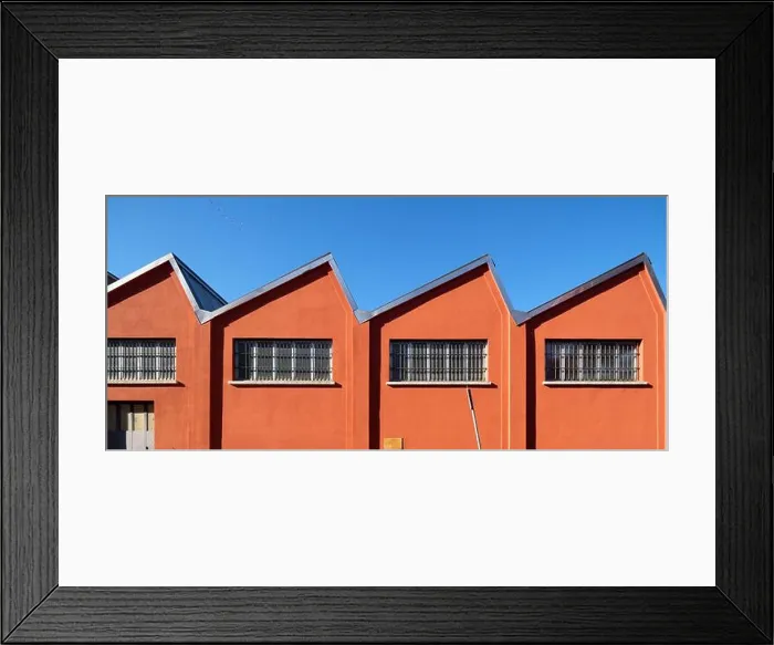 Framed Print : Old-fashioned factory shed with a deep orange facade on a blue sky Framed Print : Old-fashioned factory shed with a deep orange facade on a blue sky