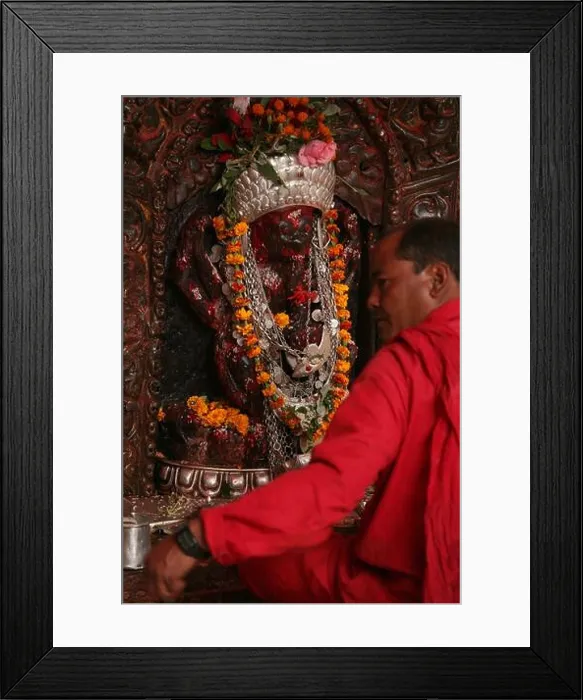 Framed Print : High priest sits in front of the statue of the goddess Kali in the main sanctuary in the Dakshinkali Temple near Framed Print : High priest sits in front of the statue of the goddess Kali in the main sanctuary in the Dakshinkali Temple near
