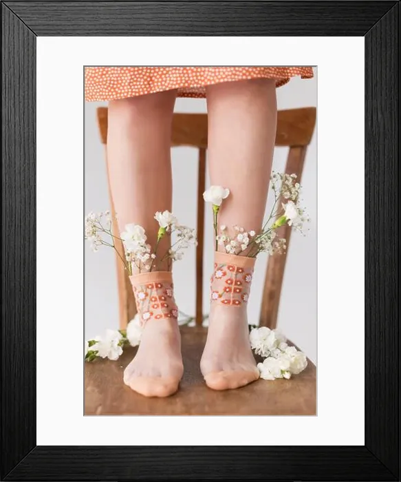 Framed Print : Woman's legs with white flowers in socks standing on chair Framed Print : Woman's legs with white flowers in socks standing on chair