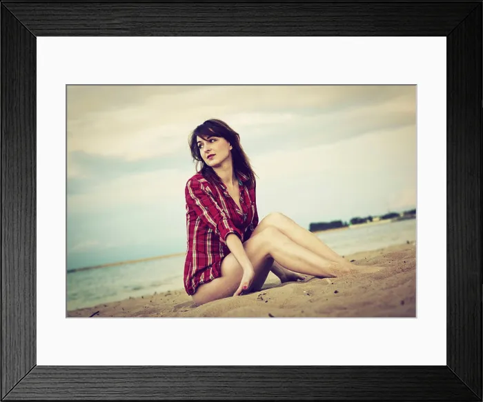 Framed Print : Young woman in a red checked shirt relaxing on the beach at sunset Framed Print : Young woman in a red checked shirt relaxing on the beach at sunset