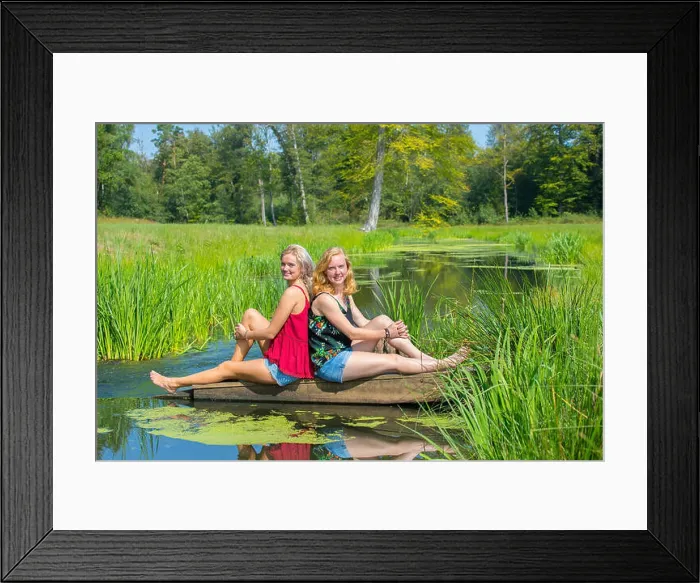 Framed Print : Two young dutch women sit at water in nature Framed Print : Two young dutch women sit at water in nature