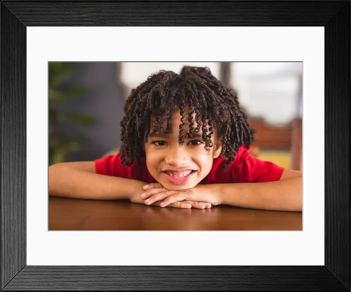Framed Print : Portrait of happy hispanic boy with curly black hair leaning on table at home Framed Print : Portrait of happy hispanic boy with curly black hair leaning on table at home