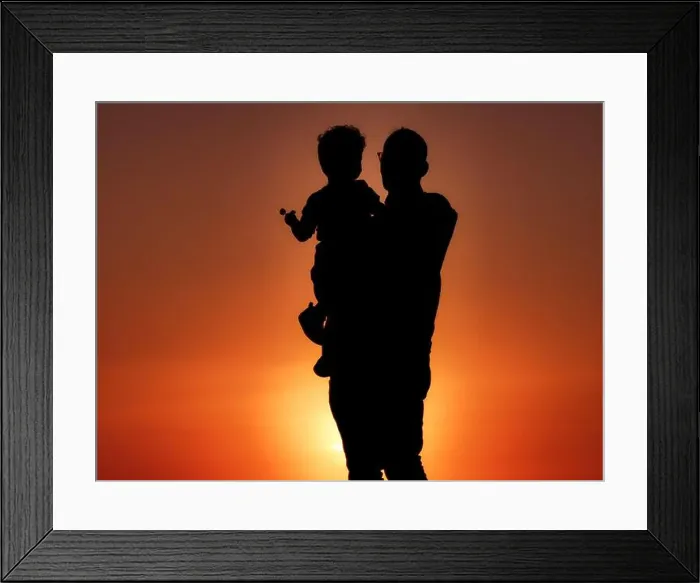 Framed Print : A silhouette of a grandfather holding his grandson with a lollipop at sunset on the coast of Cape Zebib Framed Print : A silhouette of a grandfather holding his grandson with a lollipop at sunset on the coast of Cape Zebib