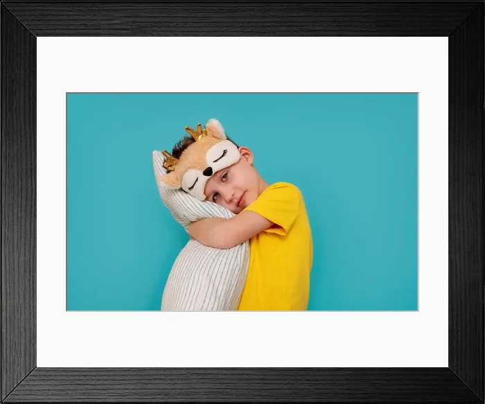 Framed Print : a boy in pajamas hugging a pillow. Banner with blue background and copy pasta Framed Print : a boy in pajamas hugging a pillow. Banner with blue background and copy pasta