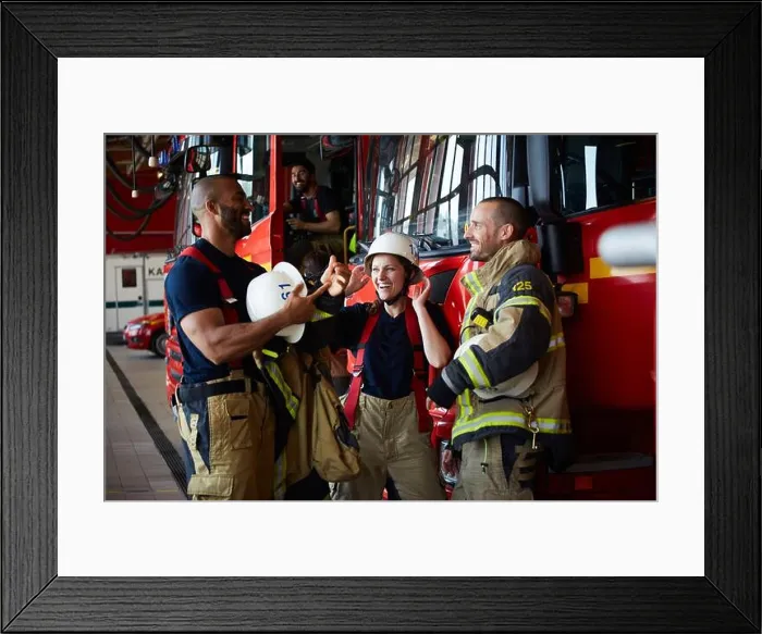 Framed Print : Happy firefighters discussing while standing by fire truck in fire station