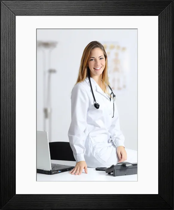 Framed Print : Beautiful female doctor sitting on the desk of her consultation Framed Print : Beautiful female doctor sitting on the desk of her consultation