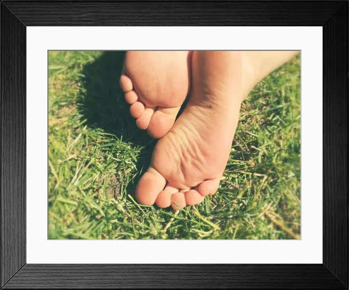 Framed Print : The soles of a young boy's Bare feet on fresh grass in the sun Framed Print : The soles of a young boy's Bare feet on fresh grass in the sun
