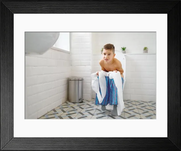 Framed Print : Frowning little boy holding paper sitting on toilet and trying to poop. Child constipation, digestive problems Framed Print : Frowning little boy holding paper sitting on toilet and trying to poop. Child constipation, digestive problems