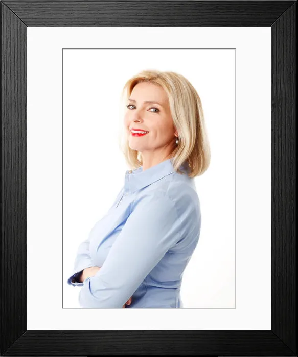 Framed Print : Portrait of attractive middle age woman standing against white background while looking at camera Framed Print : Portrait of attractive middle age woman standing against white background while looking at camera