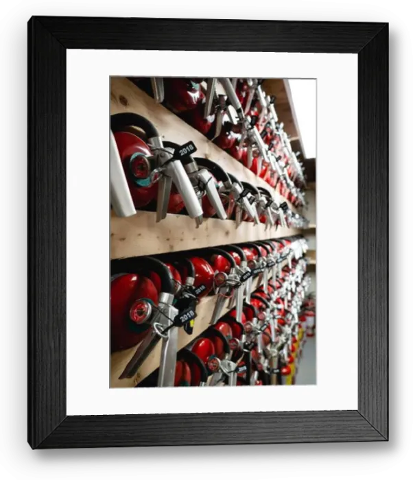 Framed Print : Fully equipped Fire extinguishers arranged and held in wood storage rack room Framed Print : Fully equipped Fire extinguishers arranged and held in wood storage rack room