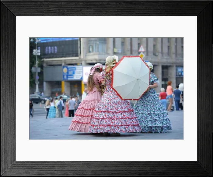 Framed Print : Three girls street vendors wearing bright vintage dresses and keeping umbrella standing on a street Framed Print : Three girls street vendors wearing bright vintage dresses and keeping umbrella standing on a street