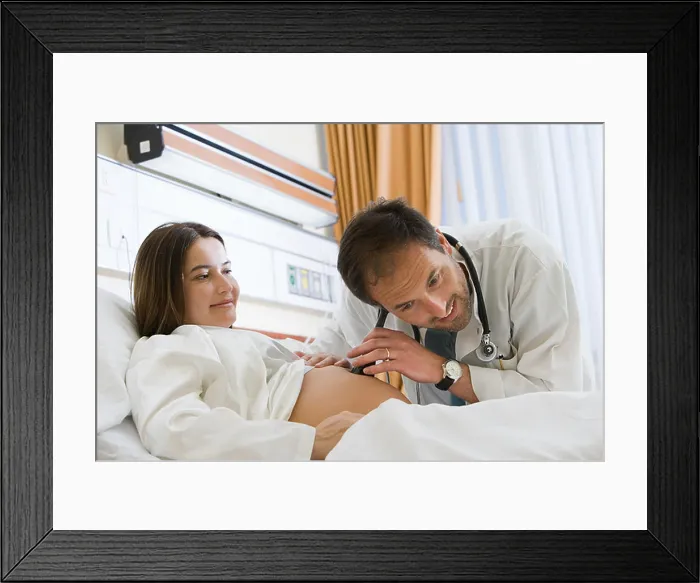 Framed Print : Pregnant woman and doctor listening to stomach Framed Print : Pregnant woman and doctor listening to stomach
