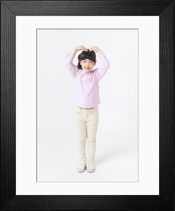 Framed Print : Young Korean girl in pink shirt putting her hand up and making heart shape with arms Framed Print : Young Korean girl in pink shirt putting her hand up and making heart shape with arms