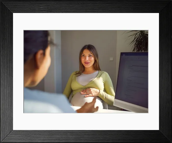Framed Print : Smiling pregnant woman discussing with female gynecologist during visit in medical clinic at hospital Framed Print : Smiling pregnant woman discussing with female gynecologist during visit in medical clinic at hospital
