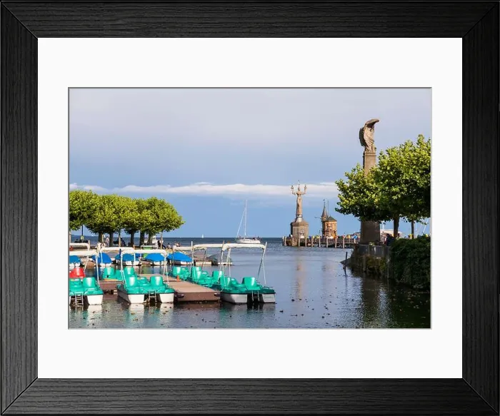 Framed Print : Konstanz at Lake Constance with pedal boats and port entrance, lighthouse and Imperial in the background Framed Print : Konstanz at Lake Constance with pedal boats and port entrance, lighthouse and Imperial in the background