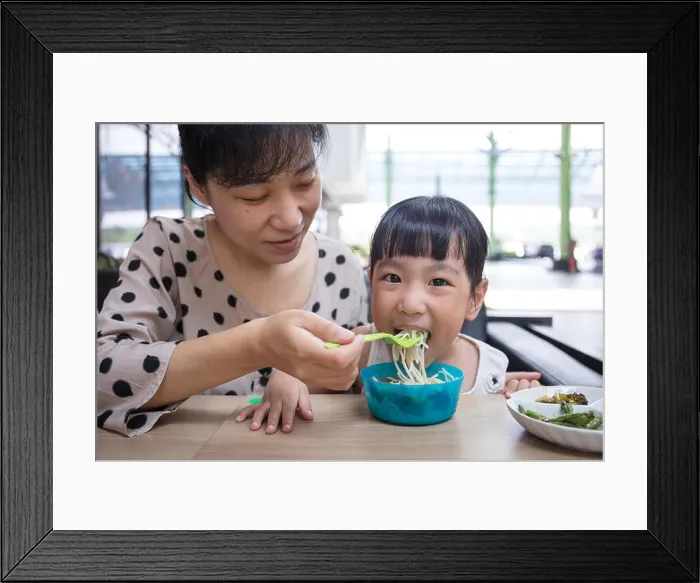 Framed Print : Asian Chinese mother and daughter eating beef noodles in outdoor cafe Framed Print : Asian Chinese mother and daughter eating beef noodles in outdoor cafe