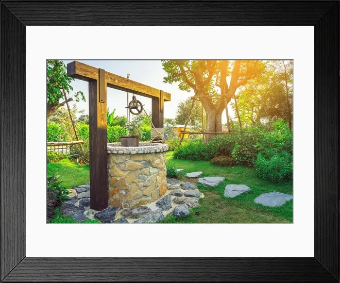 Framed Print : Beautiful artesian well made by stones and wheel pulley with metal bucket and rope in peaceful garden atmosphere Framed Print : Beautiful artesian well made by stones and wheel pulley with metal bucket and rope in peaceful garden atmosphere
