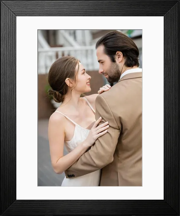 Framed Print : side view of groom in beige suit hugging smiling bride in white wedding dress, stock image Framed Print : side view of groom in beige suit hugging smiling bride in white wedding dress, stock image