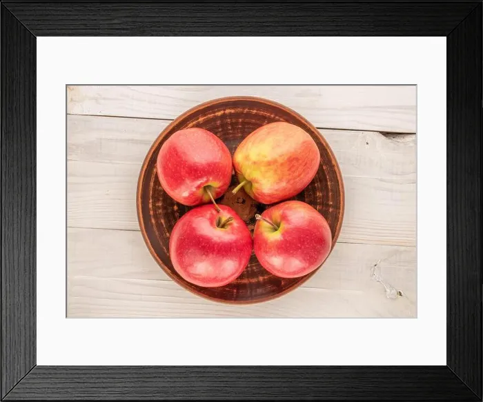 Framed Print : Four juicy red apples with a ceramic plate on a wooden table, close-up, top view Framed Print : Four juicy red apples with a ceramic plate on a wooden table, close-up, top view