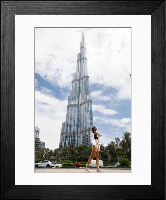 Framed Print : DUBAI, UAE. A happy young woman enjoys the view in front of the Burj Khalifa Framed Print : DUBAI, UAE. A happy young woman enjoys the view in front of the Burj Khalifa