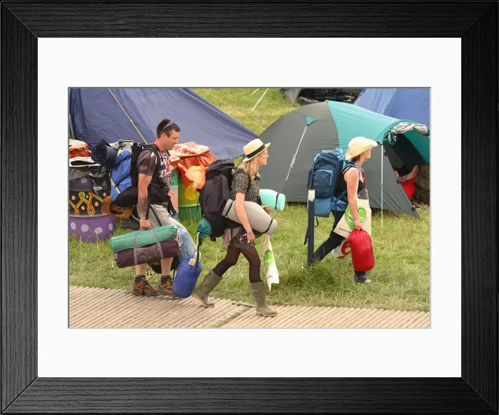 Framed Print : Glastonbury Festival fans and festival goers arrive with their backpacks Framed Print : Glastonbury Festival fans and festival goers arrive with their backpacks